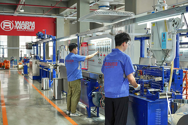 工人在操作電伴熱帶護套擠出設備。 環瑞電熱供圖